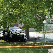 Une voiture endommagée près d'un abribus.