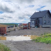 Une plateforme renversée gît au sol devant une maison unifamiliale.