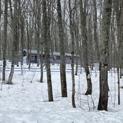 batiment dans une forêt enneigé avec des tubulures.