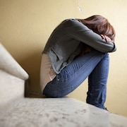 Une adolescente dans un escalier.