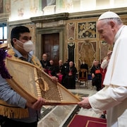 Un Autochtone offre une paire de raquettes au pape François lors d'une audience au Vatican.