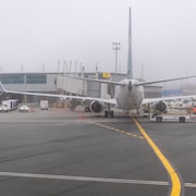 Un avion près du bâtiment de l'aéroport par une journée d'automne grise.
