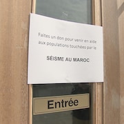 Une affiche sur une porte invite les gens à donner pour venir en aide aux personnes touchées par le séisme au Maroc.