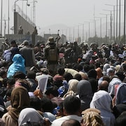 Des Afghans désespérés s'attroupent sur une route près de l'aéroport dans l'espoir de pouvoir fuir le pays.
