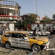 Des voitures et des bâtiments soufflés par une explosion.