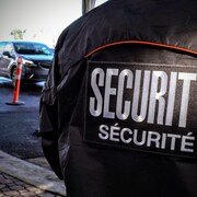 L'insigne indiquant « sécurité » sur le veston d'un gardien de sécurité.
