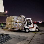 Un monte-charge amène une palette de boîtes d'aide humanitaire destinée à Gaza.