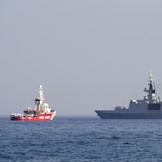 Un navire de sauvetage Open Arms, faisant partie d'une flottille de trois navires transportant de l'aide alimentaire pour la bande de Gaza, navigue à côté de la frégate française Courbet près du port de Larnaca, à Chypre, le 30 mars 2024. 