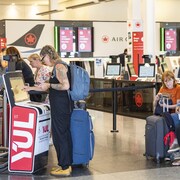 Une passagère d'Air Canada obtient sa carte d'embarquement à l'aéroport international Pierre-Elliott-Trudeau de Montréal, le mardi 19 août 2025.