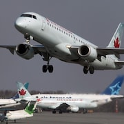 Un avion d'Air Canada décolle près d'autres appareils.