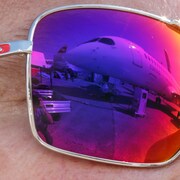 Un avion est visible dans le reflet des lunettes d'un visiteur au salon aéronautique Le Bourget. 