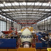 Un avion en cours d'assemblage dans une usine très moderne.