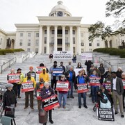Des manifestants avec des pancartes devant le Capitole de Montgomery, en Alabama.
