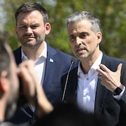 Un photographe prend un cliché de Paul St-Pierre Plamondon et Alex Boissoneault pendant que ce dernier parle.