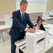 Alexis Deschênes qui glisse son bulletin de vote dans l'urne.