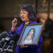Carol Todd s'exprime devant les médias en tenant une photo de sa fille, Amanda, à la sortie de la Cour suprême de la Colombie-Britannique à New Westminster, le 14 octobre 2022. 