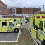 Des ambulances stationnés devant un hôpital.