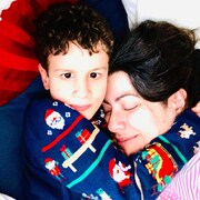 Amir et sa mère Dounia sont couchés.  Amir serre sa mère dans ses bras.