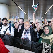 Un groupe d'hommes et de femmes faisant le signe de la paix.