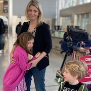 Un portrait de Amy Bannon et de ses enfants à l'aéroport.