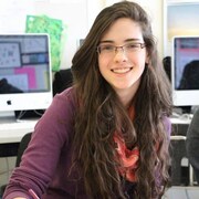 Amy Fahlman est assise souriante devant un ordinateur.