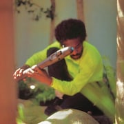 L'artiste tient une flûte qui ressemble à un sabre laser. 
