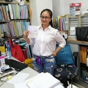 Une femme dans un bureau aux murs chargés de dossiers.