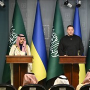 Faisal bin Farhan Al Saud, Andryi Yermak et Dmytro Kouleba sont côte à côte derrière des lutrins. Des drapeaux de l'Ukraine et de l'Arabie saoudite se trouvent derrière eux.