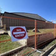 L'aréna vu de coté avec une grille orange et une pancarte avec inscrit "no entry"