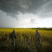 Deux soldats russes dans un champ  sous un ciel menaçant.