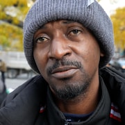 Le demandeur d'asile portant une tuque en entrevue devant le 129, rue Peter, un bureau pour sans-abri à Toronto.