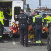 Des policiers et des ambulanciers dans la rue.