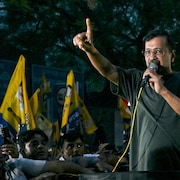 Arvind Kejriwal, debout, parle dans un micro, entouré d'une foule, le 10 mai 2024, à New Dehli.