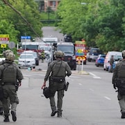 Des policiers marchent sur une rue. 