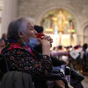 Une femme autochtone dans un fauteuil roulant qui assiste à la messe du pape.