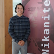 Un homme devant une affiche.