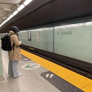 Une personne attend le métro, seule sur le quai, à la station St. George, à Toronto.