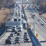 Des voitures et des camions roulent sur l'autoroute 401.