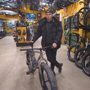 Antonin Durand debout au milieu de vélos dans un magasin de Winnipeg au Manitoba. 
