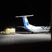 Un avion-ambulance et une ambulance sur le tarmac.