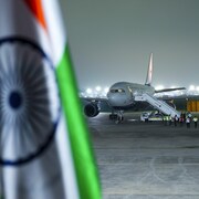 Un avion du gouvernement est sur un tarmac, alors que flotte un drapeau de l'Inde.