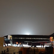 Un avion de la compagnie Chrono sur la tarmac de l'aéroport, la nuit.