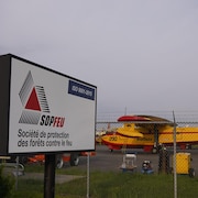 Deux avions-citernes sur le tarmac de l'aéroport de Val-d'Or. Une enseigne annonce les bureaux de la Société de protection des forêts contre le feu.