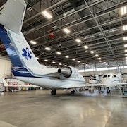 Trois avions garés dans un hangar.