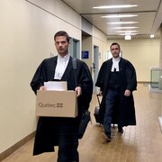 Les deux hommes vêtus de leur toge dans un corridor du palais de justice.
