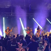 Le groupe BackStabber en prestation sur la scène de l'AlienFest, devant une foule.