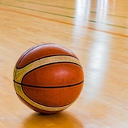 Un ballon de basketball sur le sol d'un gymnase. 