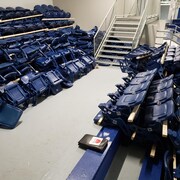 Des bancs empilés dans les gradins d'un aréna. 