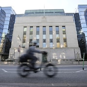 Un cycliste passe devant l'&eacute;difice de la Banque du Canada.