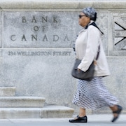 Une femme passe devant l'édifice de la Banque du Canada, à Ottawa, le 6 septembre 2023. 